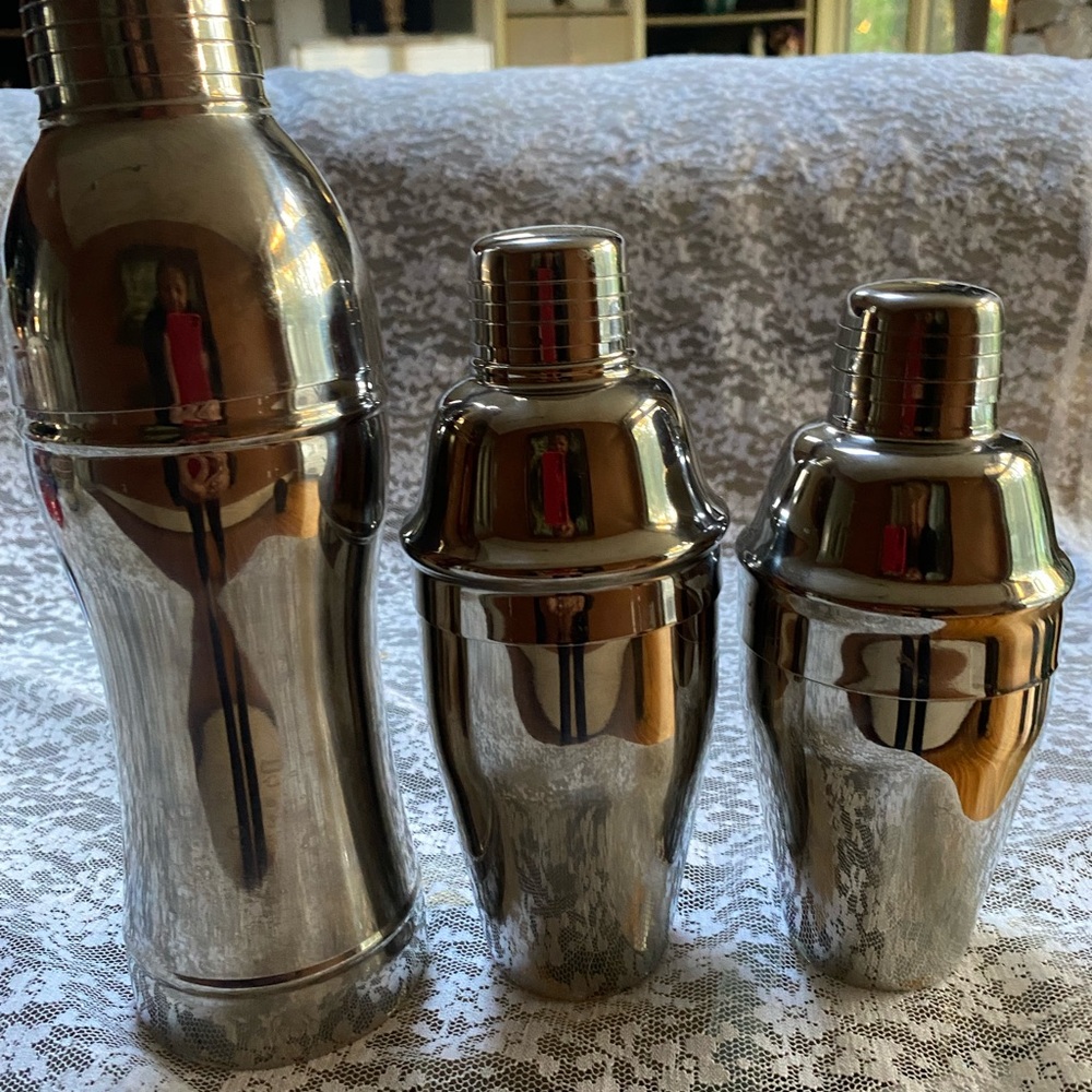 Three different size stainless steel martini shakers.